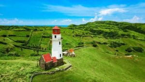 Mahatao Spanish Lighthouse amidst lush green hills in Batanes, Philippines.