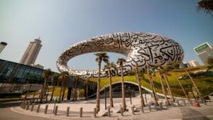 The striking architecture of Dubai's Museum of the Future, featuring calligraphic patterns and a unique elliptical shape surrounded by greenery.