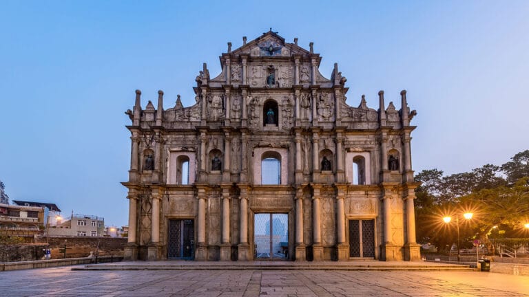 The historic facade of the Ruins of St. Paul's in Macau, illuminated during twilight, showcasing its intricate design.