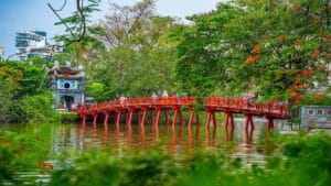 "The Huc Bridge in Hanoi, Vietnam, connecting to Ngoc Son Temple, surrounded by lush greenery.